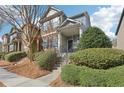 Inviting townhome featuring a covered front porch with swing, stone accents, and manicured landscaping at 5227 Whiteoak Se Ave, Smyrna, GA 30080