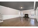 Bright and spacious living room with hardwood floors, fireplace, and white trim with wainscotting at 9610 Cedar Grove Rd, Fairburn, GA 30213