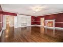 Large living room featuring hardwood floors, an elegant fireplace, and custom built-ins at 9610 Cedar Grove Rd, Fairburn, GA 30213