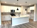 Modern kitchen features white cabinets, stainless steel appliances, and a center island with quartz countertop at 115 Laurel Farms Ln, Dallas, GA 30157