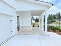 Covered porch with white columns, brick accents, and concrete flooring creates an inviting entry at 650 Redhead Way (Lot 25), Grayson, GA 30017