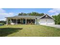Charming home with a covered front porch, two-car garage, and lush green lawn at 410 Bowen Ne Rd, White, GA 30184