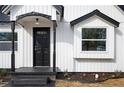 Inviting front entrance with a black door, bay window, and colorful flower bed at 65 Sage St, Temple, GA 30179