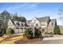 Elegant two-story home boasts a three-car garage, manicured landscaping, and a welcoming front entrance at 12710 Old Surrey Pl, Roswell, GA 30075