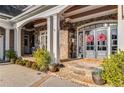 Inviting front porch featuring stone columns, elegant double doors with wreaths, and detailed stonework at 12710 Old Surrey Pl, Roswell, GA 30075