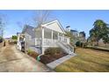 Side view showcasing a quaint home with a cozy front porch, manicured lawn, and mature trees at 2796 Georgian W Dr, Brookhaven, GA 30341