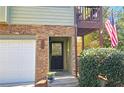 Close up of front entrance with stone facade, black door, and an American flag on upper deck at 3699 Ashford Creek Ne Hl, Atlanta, GA 30319