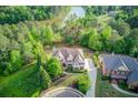 Breathtaking aerial view of a luxurious home nestled among lush greenery and serene lake surroundings at 2400 Weber Heights Way, Buford, GA 30519