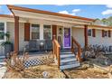 Welcoming front porch featuring cozy seating, decorative elements, and well-maintained landscaping at 4493 Old Hiram Lithia Spgs Rd, Powder Springs, GA 30127