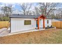 Single story home featuring white siding, brick accents, a blue front door and manicured landscaping at 926 Natham Dr, Atlanta, GA 30315