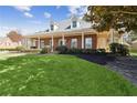 Charming brick home with a well-manicured front lawn, mature trees, and inviting covered porch at 320 Morganshire Pl, Atlanta, GA 30350