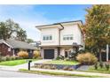 A modern two-story home with an attached garage, crisp white siding, and a well-maintained green lawn at 416 Glen Iris Ne Dr, Atlanta, GA 30308