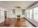 Spacious living room features a fireplace, built-in shelving, hardwood floors, and lots of natural light at 3780 Baxley Pine Trl, Suwanee, GA 30024