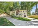 Charming home with black framed windows and a modern two-car garage, surrounded by lush greenery and a long driveway at 2423 Melinda Ne Dr, Atlanta, GA 30345