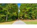 Tree-lined walking path surrounded by lush greenery, perfect for enjoying nature within the community at 13238 Tolstoy, Covington, GA 30014