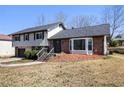 Inviting two-story house featuring a brick facade, bay window, and landscaped front yard with mature trees at 5419 Golfcrest Cir, Stone Mountain, GA 30088