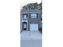 Brick facade townhome with individual garage, a balcony, and symmetrical window and door placement at 1530 Viero Dr, Lawrenceville, GA 30044