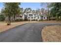 Charming home featuring a circular driveway and a manicured front yard with mature trees at 4770 Hilltop Nw Dr, Acworth, GA 30101