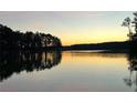 Beautiful sunset view over a tranquil lake with silhouetted trees and calm water at 4770 Hilltop Nw Dr, Acworth, GA 30101