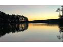 Scenic lake view at sunset with golden light reflecting on the calm water and silhouetted trees at 4770 Hilltop Nw Dr, Acworth, GA 30101
