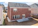 Rear view of brick home with walk-out patio and green grass at 5819 Rue Chase Way, Tucker, GA 30084