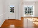 Bright living room features wood floors, large windows, and a white front door at 5819 Rue Chase Way, Tucker, GA 30084