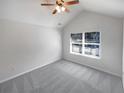 Cozy bedroom with neutral carpet, a vaulted ceiling, and a bright window overlooking the yard at 755 Autumn Blfs, Fairburn, GA 30213