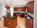Well-equipped kitchen with dark wood cabinets, stainless steel appliances, and a central island at 755 Autumn Blfs, Fairburn, GA 30213