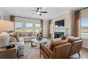 Bright living room with a fireplace, ceiling fan, large windows, and comfortable seating at 146 Silver Leaf Trce, Douglasville, GA 30134