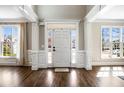 Bright foyer featuring hardwood floors, wainscoting, transom window, and white trim at 4048 Sandy Branch Ne Dr, Buford, GA 30519