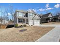 Charming two-story home with grey siding and white trim plus a two-car garage and long driveway at 66 Snowdon Way, Villa Rica, GA 30180