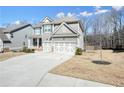 Charming two-story home with grey siding and white trim plus a two-car garage and long driveway at 66 Snowdon Way, Villa Rica, GA 30180