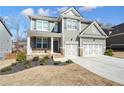 Charming two-story home with grey siding, stone accents, a covered porch, and a two-car garage at 66 Snowdon Way, Villa Rica, GA 30180