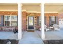 Charming covered front porch with seating, columns, and a welcoming entrance at 2401 Day Break Way, Dacula, GA 30019