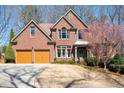 Charming two-story brick home featuring a well-manicured lawn and a two-car garage at 5034 Kingsbridge Pass, Powder Springs, GA 30127