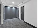 Hallway with carpet flooring, leading to several doors at 620 Peachtree Ne St # 1613, Atlanta, GA 30308