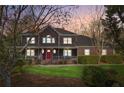 Charming two-story home at dusk, featuring a welcoming front porch, well-maintained lawn, and a red front door at 703 Somerset Dr, Lawrenceville, GA 30046