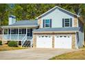 View of the home's exterior showcasing the covered porch, stone accents, and a two-car garage at 195 W Fork Way, Temple, GA 30179