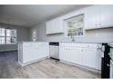 Bright kitchen with white cabinets, modern stainless steel appliances, and beautiful wood flooring at 195 W Fork Way, Temple, GA 30179