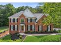 Beautiful brick home with lush green lawn, manicured landscaping and a classic architectural design at 4780 Woodruff Trce, Cumming, GA 30028