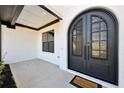Close-up of a modern home's entryway featuring sleek black double doors and white brick at 3057 Bold Springs Rd, Dacula, GA 30019