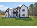 Beautiful two-story home with a well-manicured lawn, black trim, and modern design at 3057 Bold Springs Rd, Dacula, GA 30019