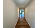 Hallway featuring hardwood floors and neutral-colored walls leading to rooms with natural light at 660 Redhead Way (Lot 24), Grayson, GA 30017