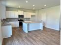 Open kitchen featuring white cabinets, stainless steel appliances, and a central island at 660 Redhead Way (Lot 24), Grayson, GA 30017