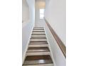 Staircase with hardwood steps and a white painted riser and stringer at 660 Redhead Way (Lot 24), Grayson, GA 30017