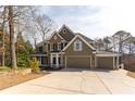 Charming two-story home with a stone and siding exterior, three-car garage and well-manicured landscaping at 764 Sharpshooters Nw Rdg, Marietta, GA 30064
