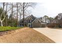 Beautiful two-story home with a spacious driveway, three-car garage and a stone retaining wall along the lawn at 764 Sharpshooters Nw Rdg, Marietta, GA 30064