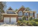 Charming brick home featuring a two-car garage and lush landscaping in a residential setting at 5106 Vinings Estates Se Way, Mableton, GA 30126