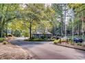 Community entrance with well-manicured landscaping and a guard house in a lush green setting at 80 Montre Nw Sq, Atlanta, GA 30327