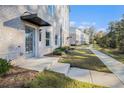 Charming townhome exterior with a light brick facade, covered entryway, and a landscaped walkway at 139 Jameson E Dr, Acworth, GA 30102